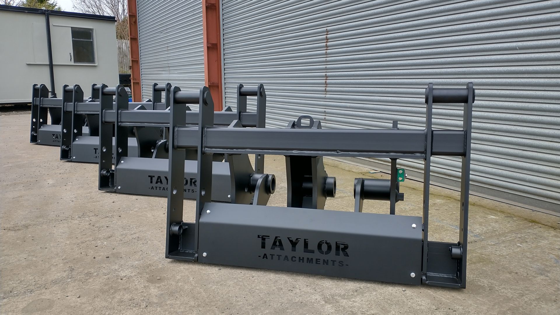 A row of taylor attachments are sitting in front of a building.