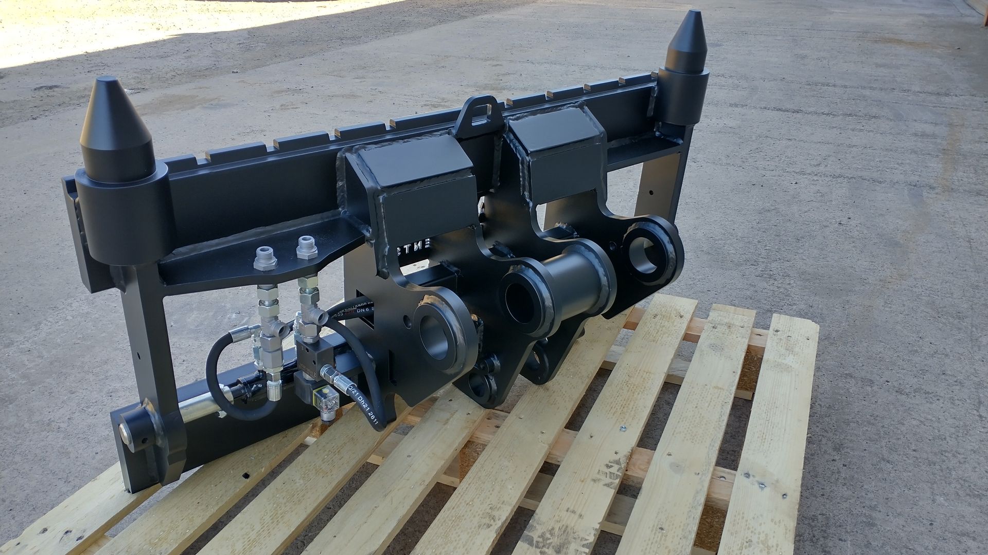 A black object is sitting on top of a wooden pallet.