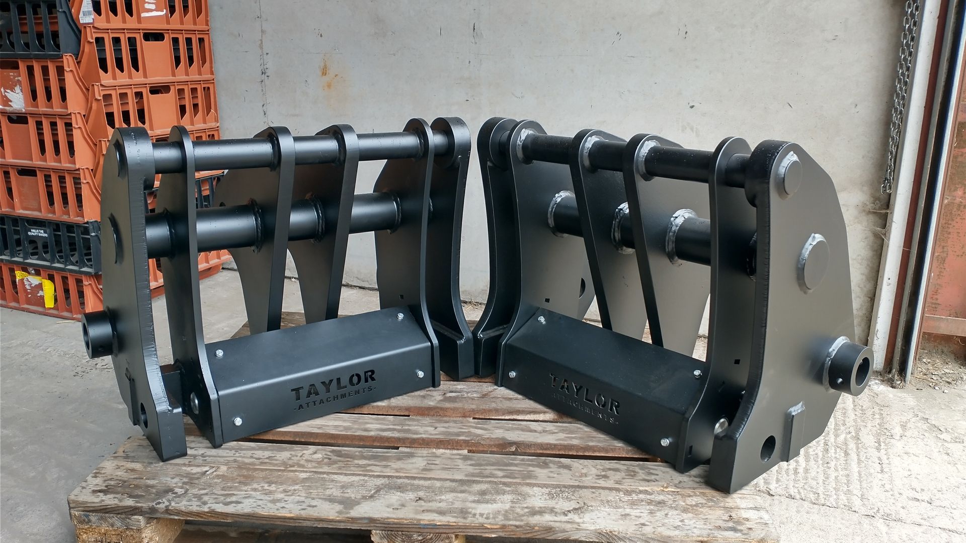 Two pieces of metal are sitting on top of a wooden pallet.