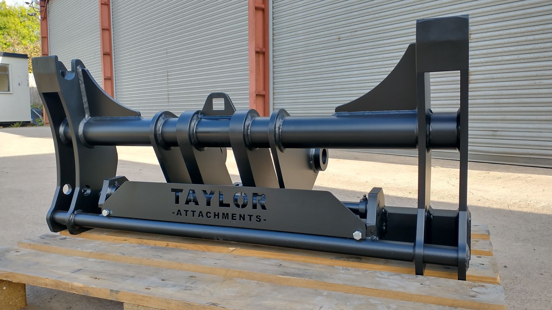 A black metal object is sitting on top of a wooden pallet.