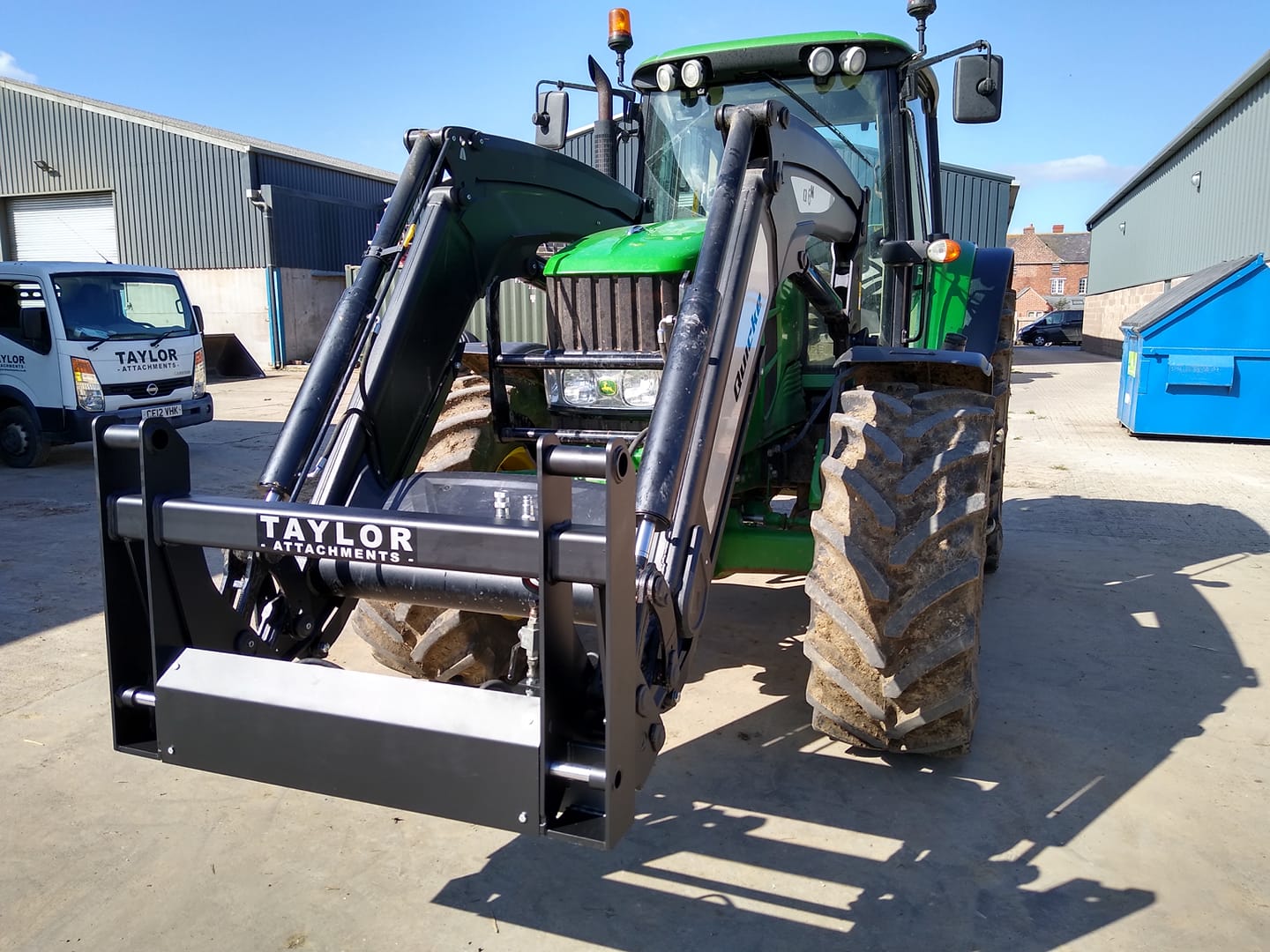 A green tractor is parked in a parking lot.