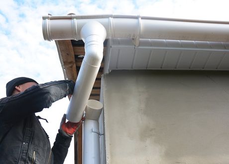 man fixing/connecting the roof gutter