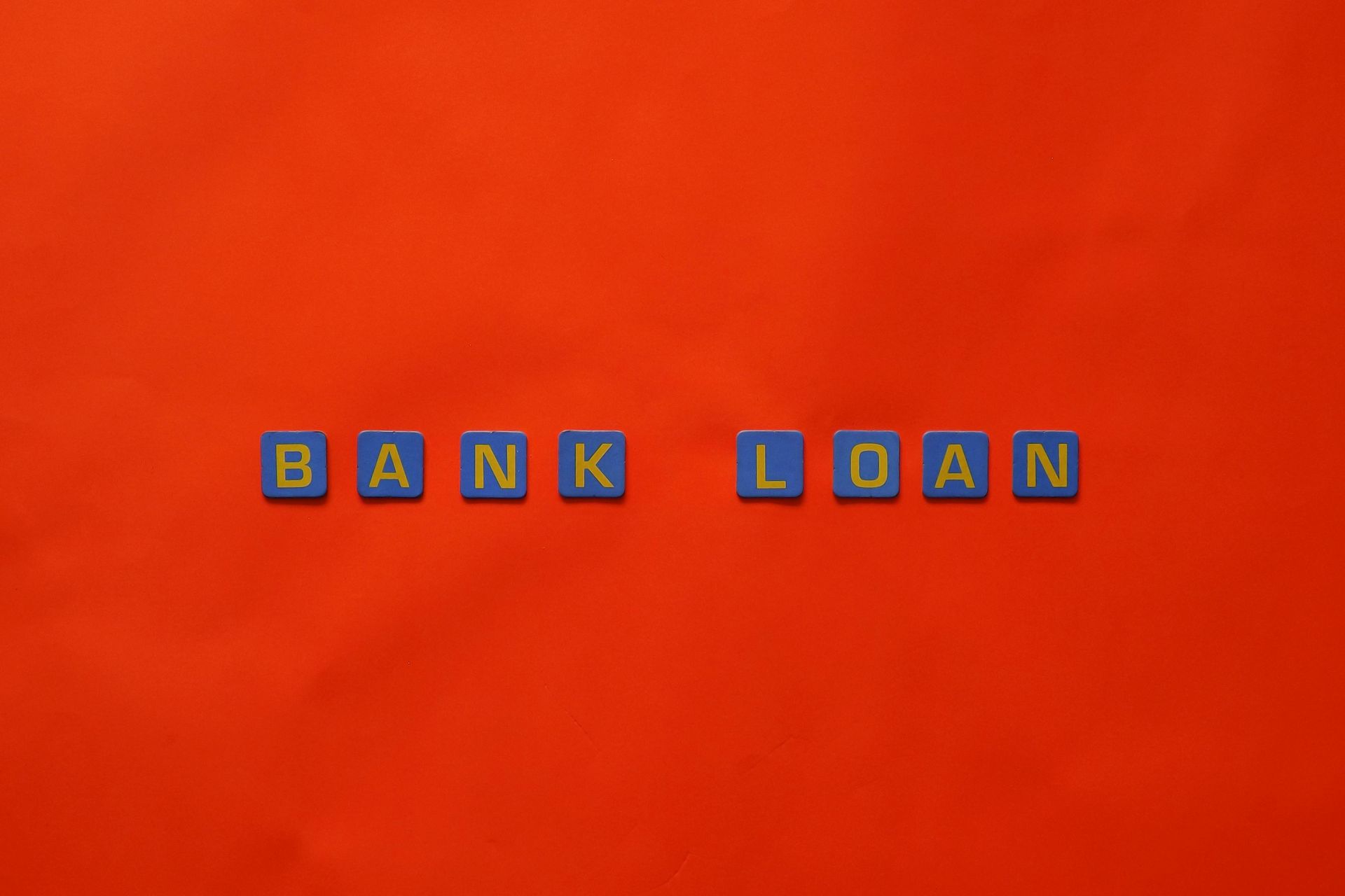 The word bank loan is written in blue blocks on an orange background
