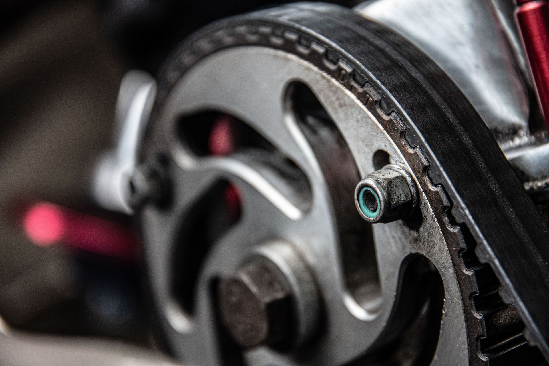 Close-up of a car engine timing belt and pulley mechanism with metallic components