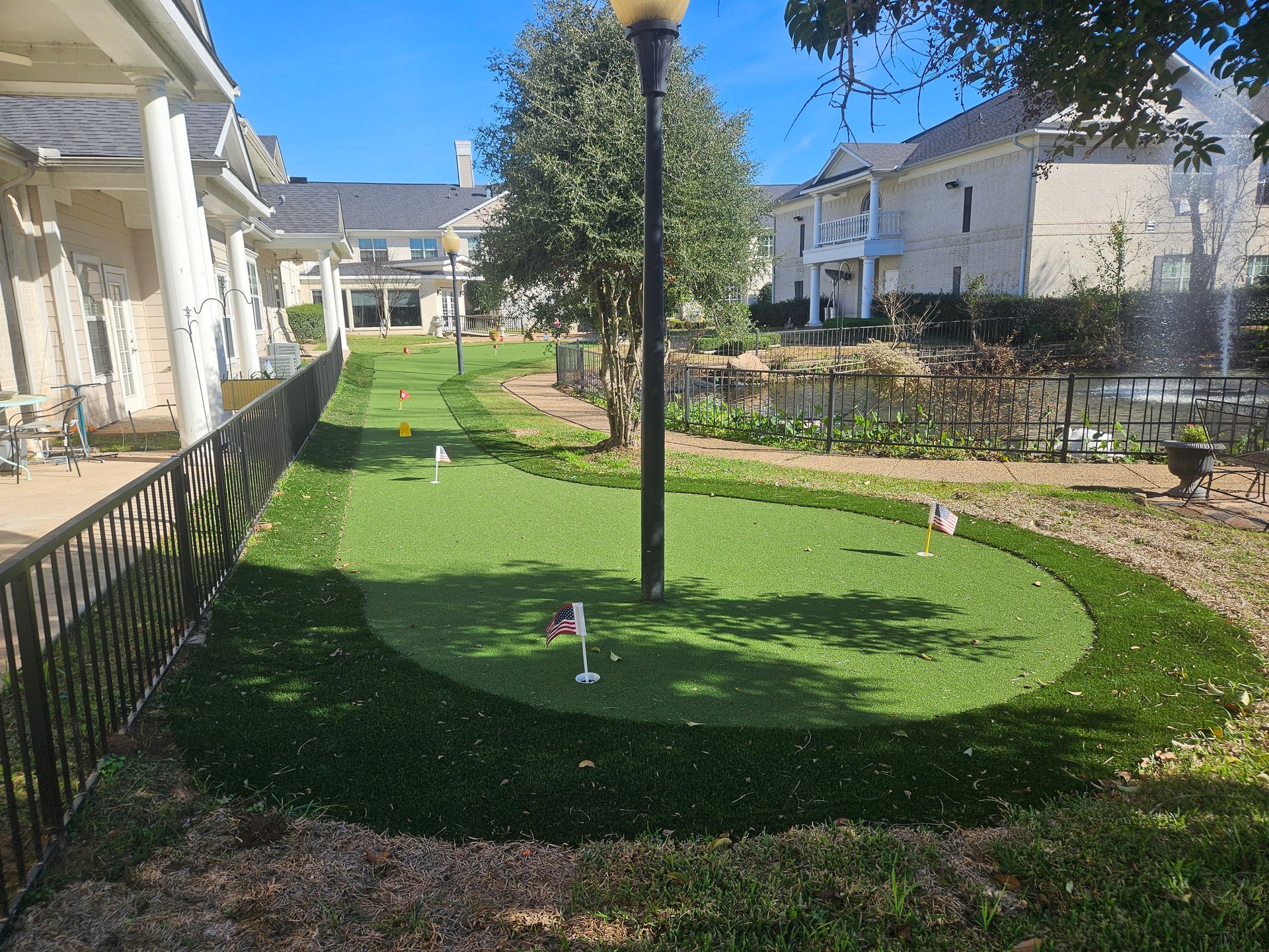 A group of people are sitting at tables in a large room with balloons hanging from the ceiling.