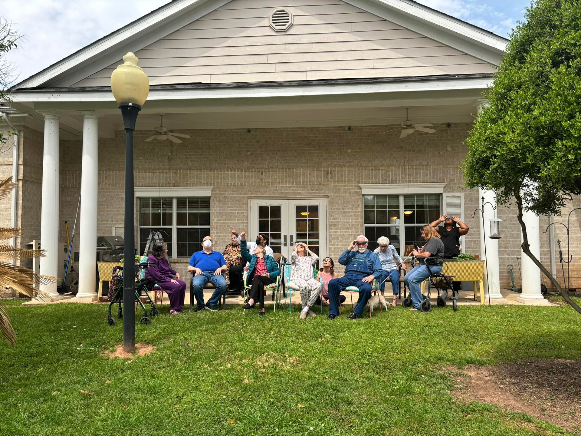 A group of people are sitting in front of a building.