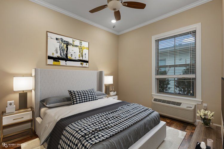 A bedroom with a large bed and a ceiling fan