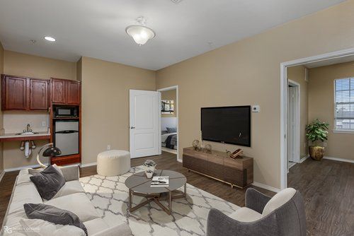 A living room with a couch , chair , coffee table and television.