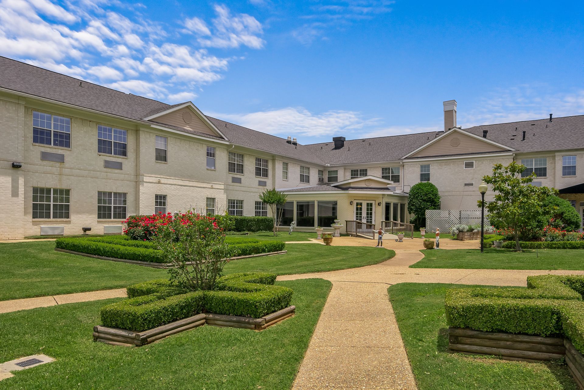 A large white building with a lush green lawn in front of it.