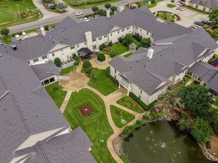 An aerial view of a large building with a pond in the middle