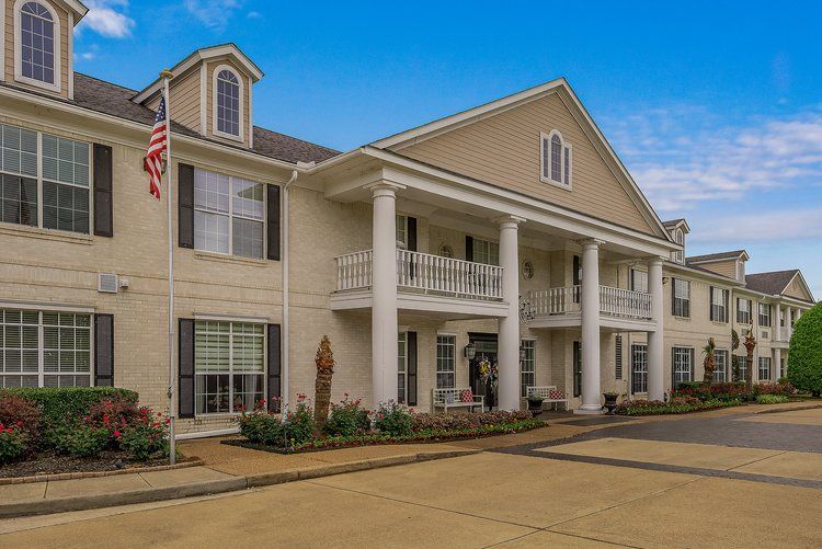 A large white building with columns and a flag in front of it.