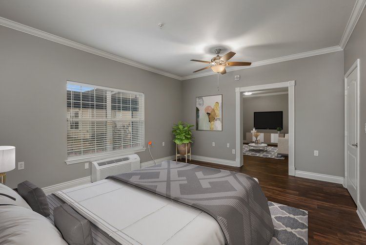 A bedroom with a large bed and a ceiling fan.