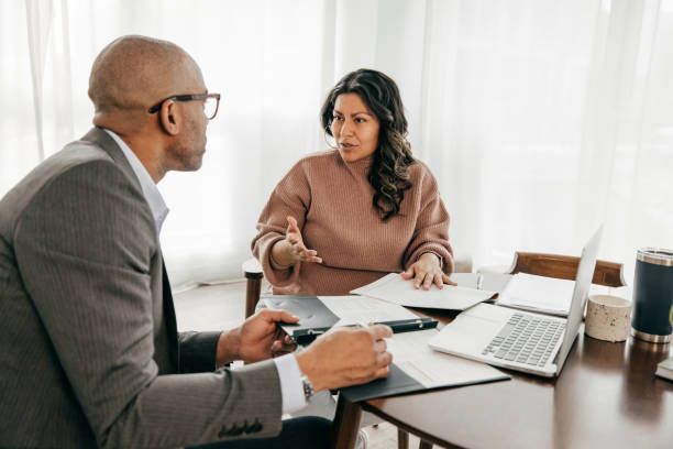 A man and a woman are sitting at a table having a conversation.