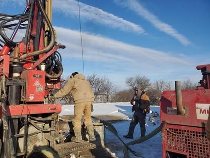 Two Men Are Working On A Machine In The Snow - Union City, IN - Wiley Well Drilling