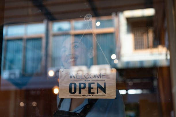 Woman smiles through shop window, flips 