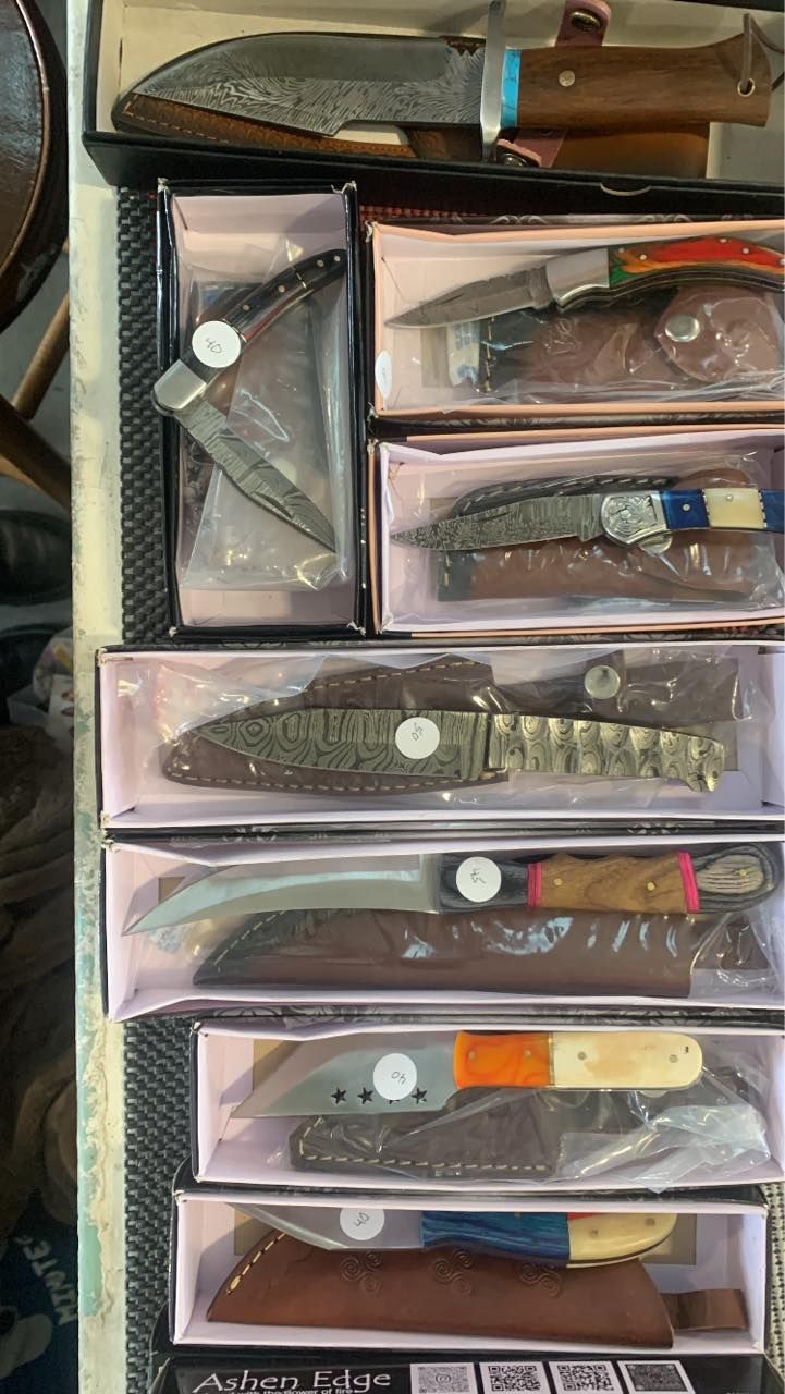 Collection of various knives displayed in boxes.