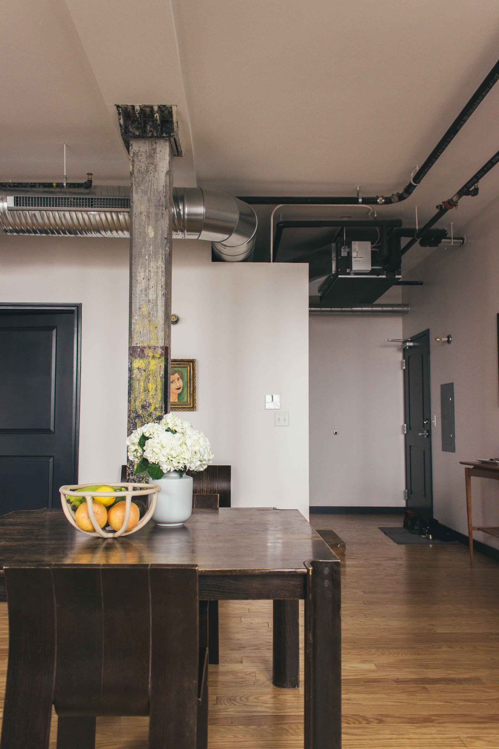A loft space with a virginia sin fruit bowl, hydrangeas, and a dutch modern dining table