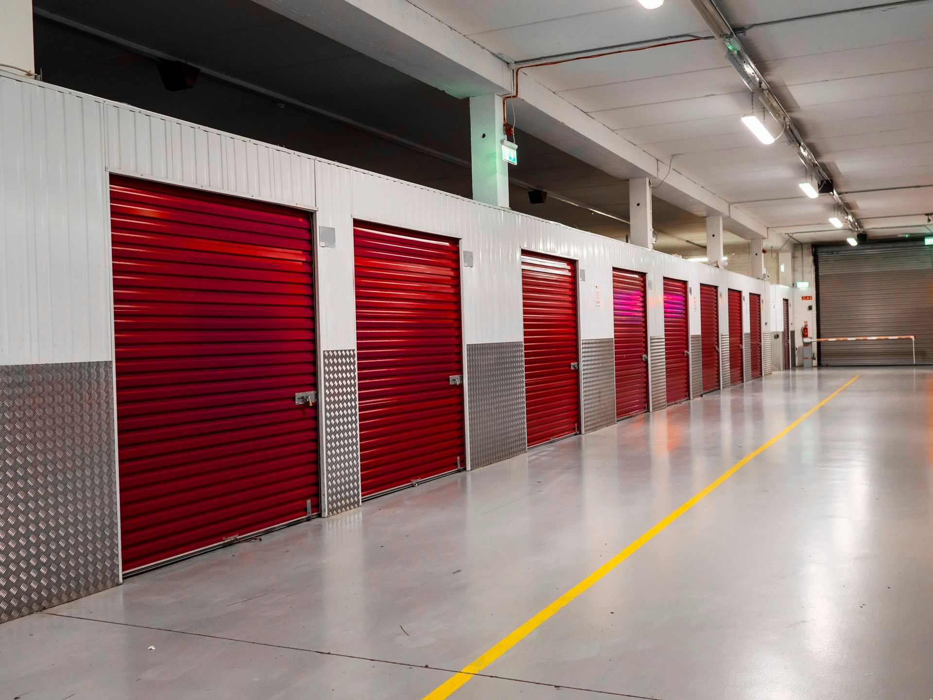 Long row of red color doors of self storage facility. Service to keep safe extra belongings.