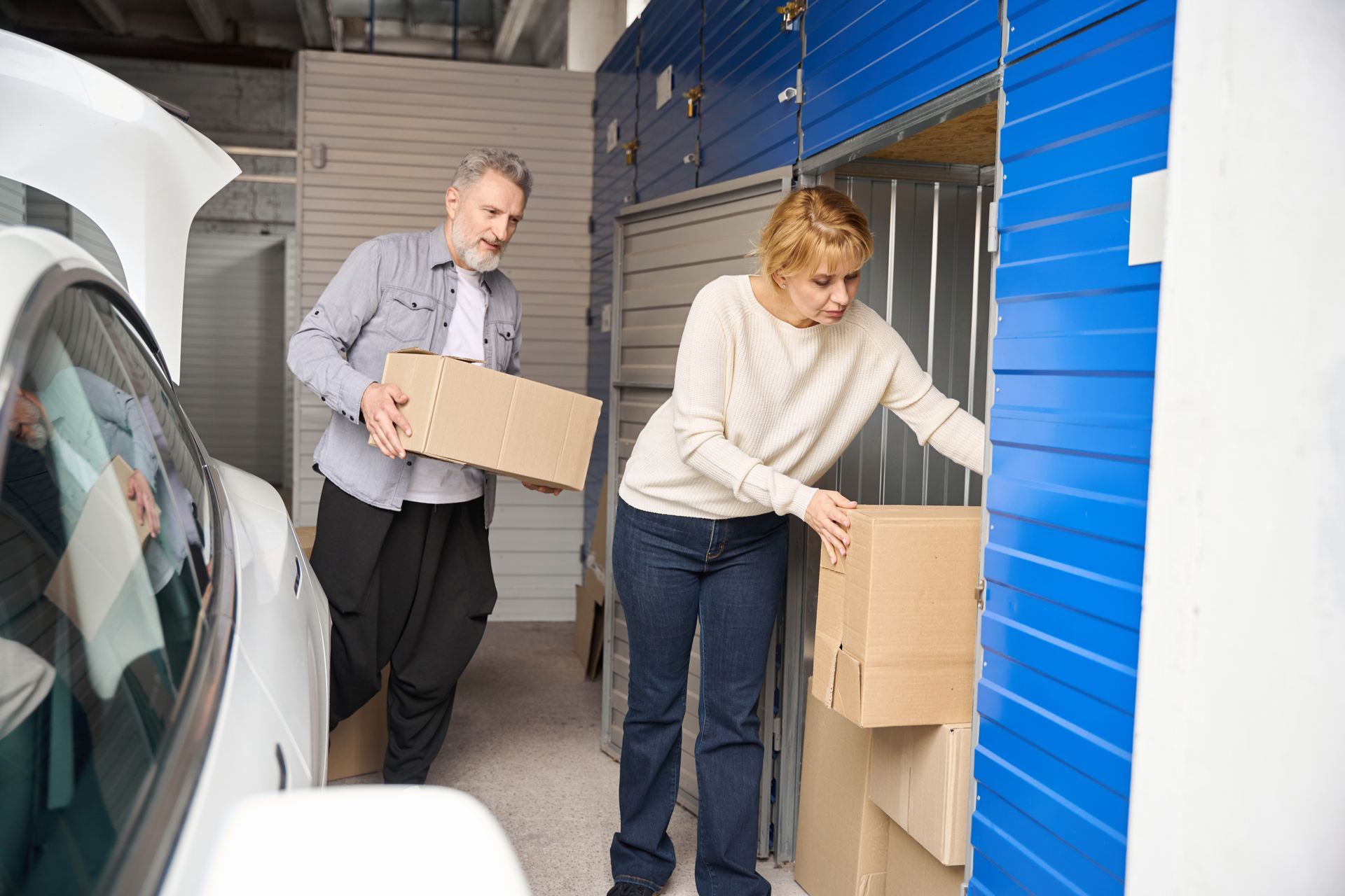 A couple is carrying boxes to a self-storage unit.