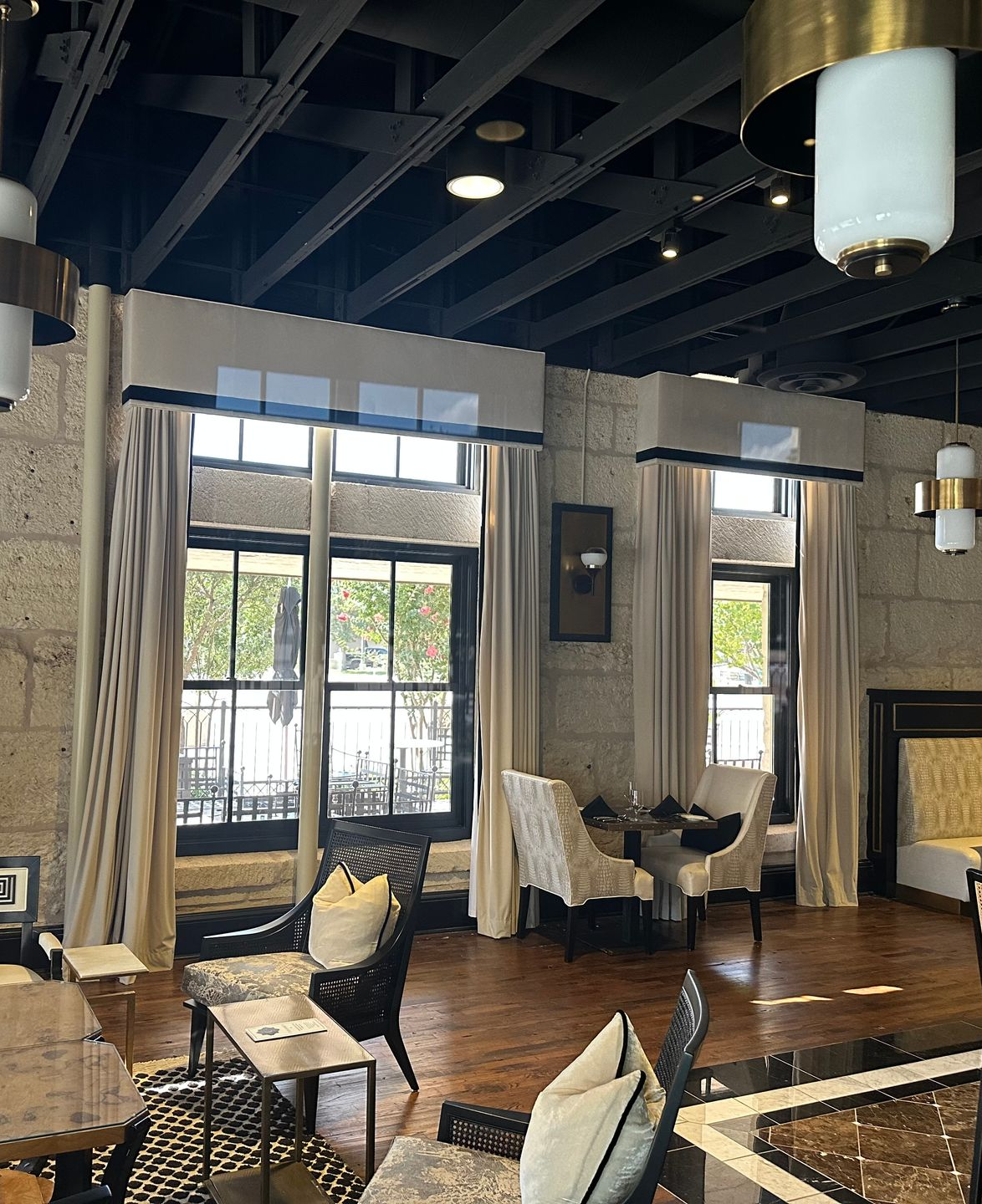 Exterior entrance with a ramp. Glass door open revealing a ramp leading to the street. A person's reflection is visible in the glass.