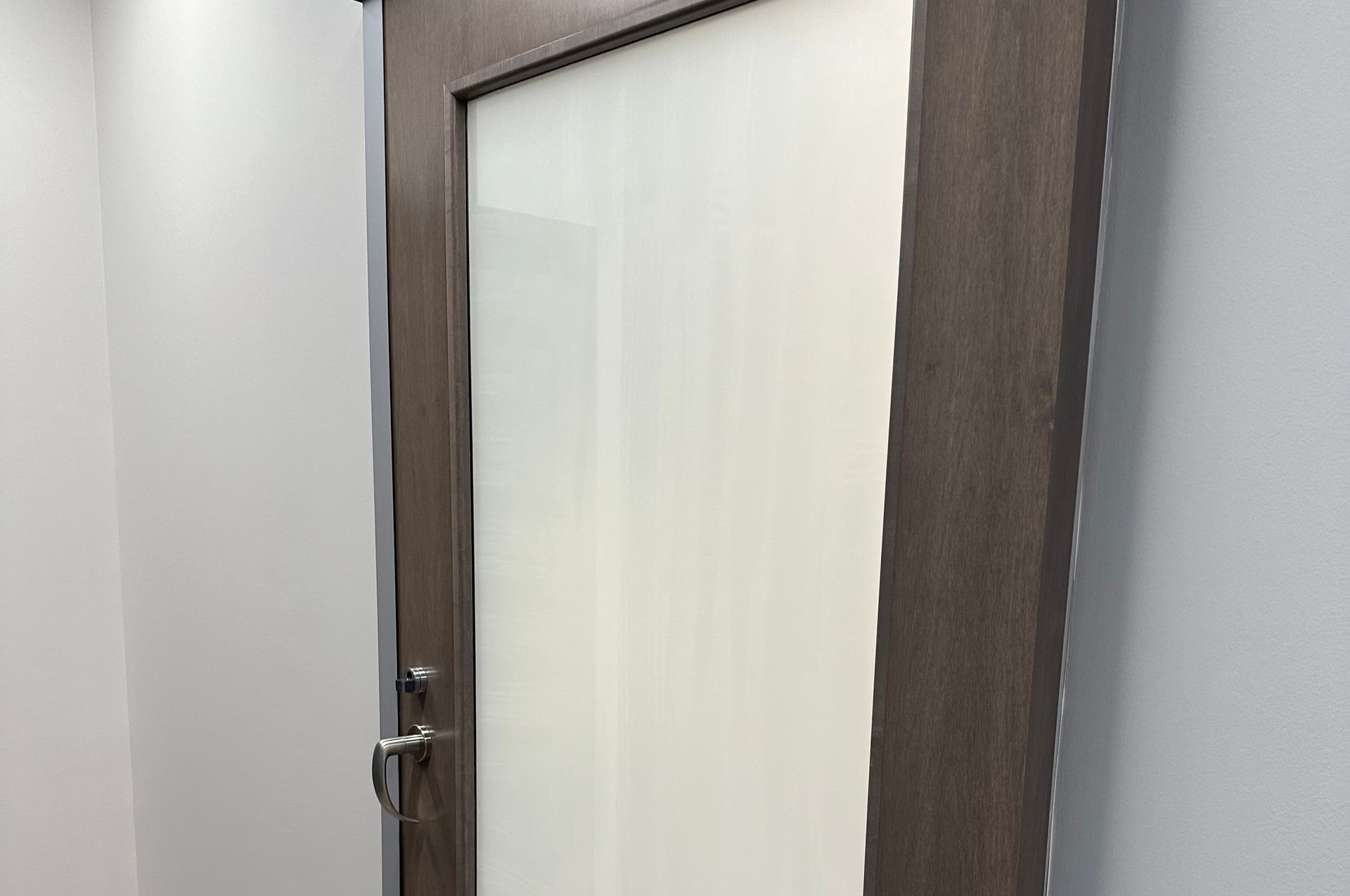 Modern high-rise building with a facade of irregularly shaped blue glass and dark panels reflecting the sky.