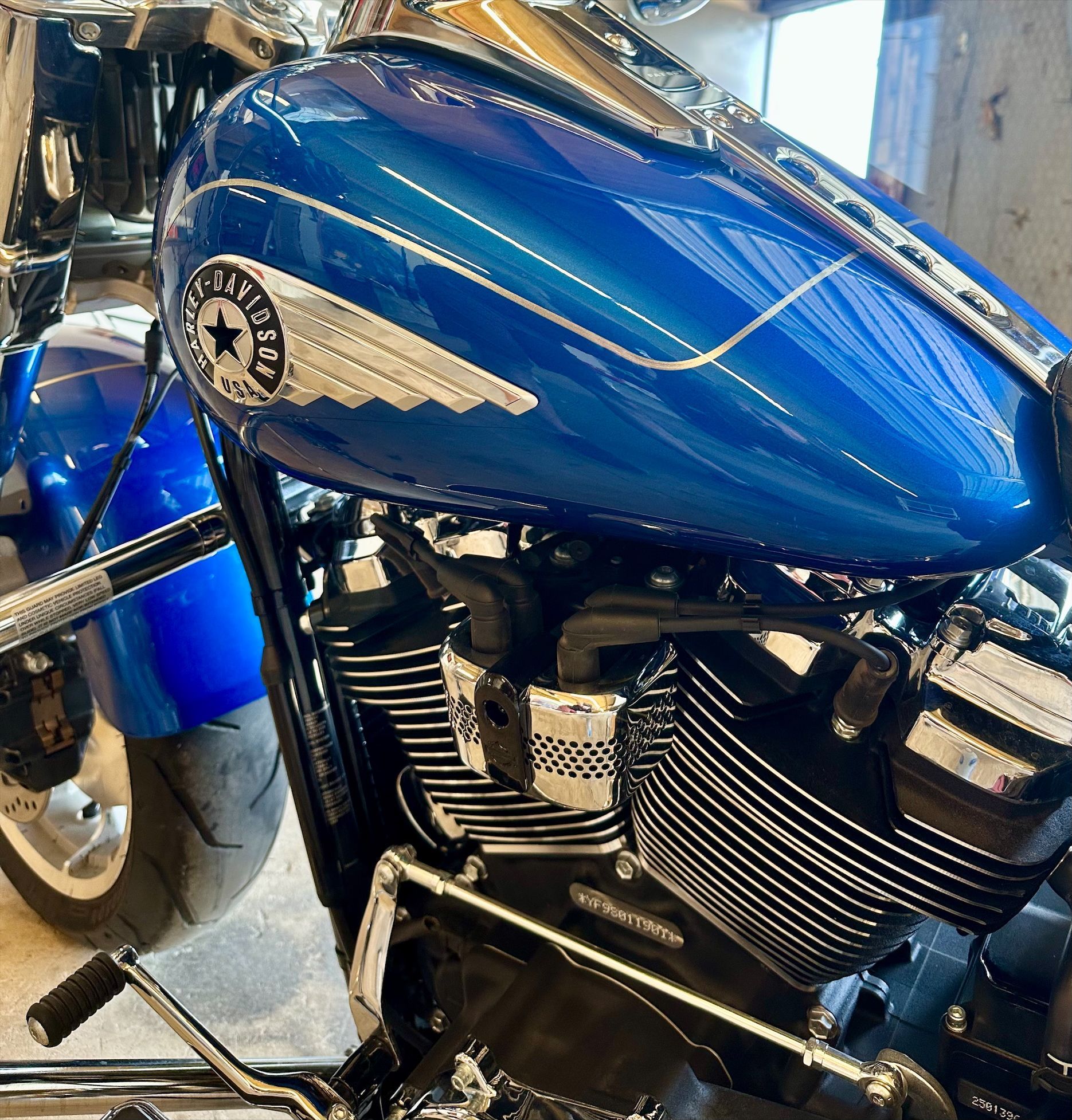 Blue motorcycle with a star and wing emblem on the fuel tank.