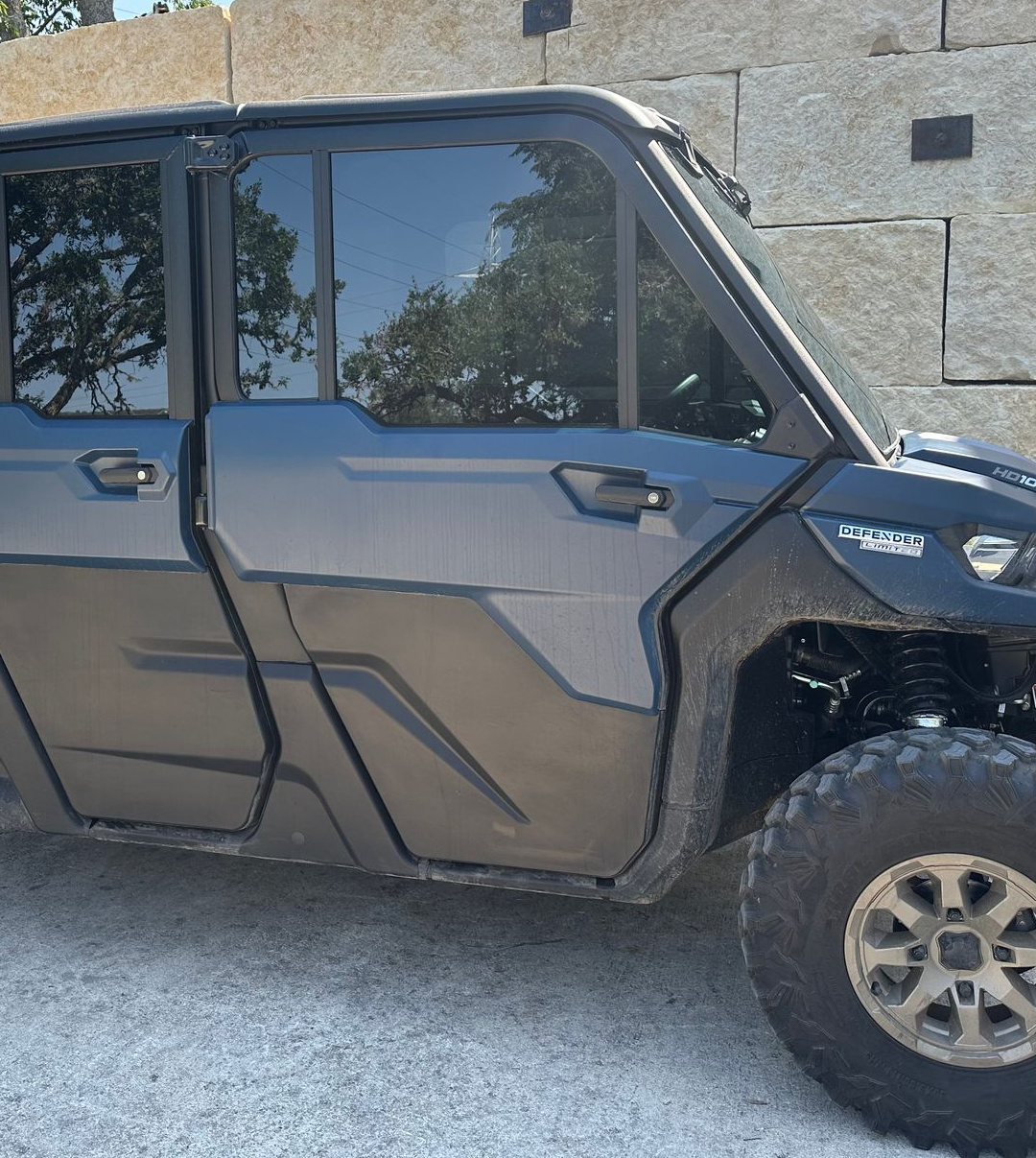 Black utility vehicle parked near a stone wall.