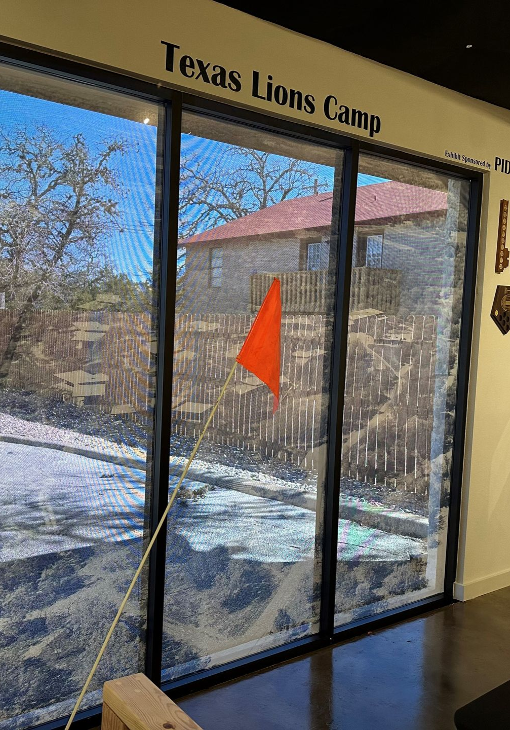 Elegant interior with large windows, stone walls, and modern light fixtures. Furnished with chairs and tables in a bright, open space.