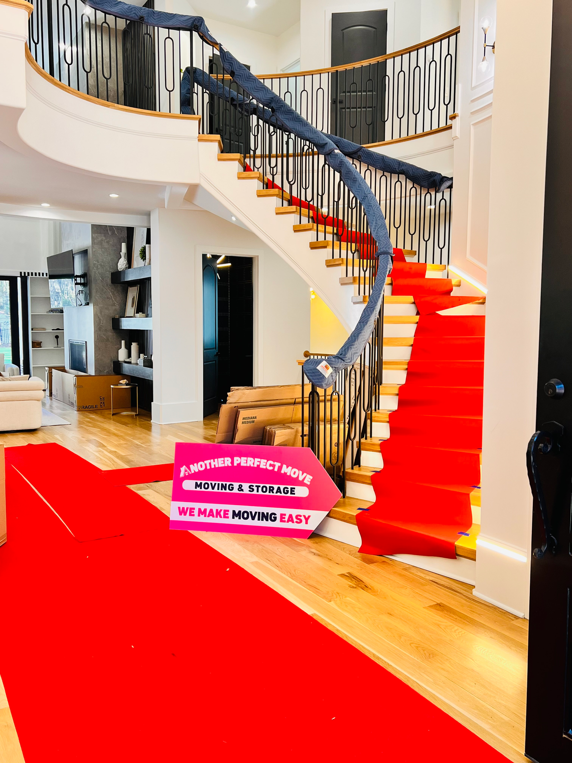 A staircase with a red carpet and a sign that says Another Perfect Move Moving and Storage, We Make Moving Easy