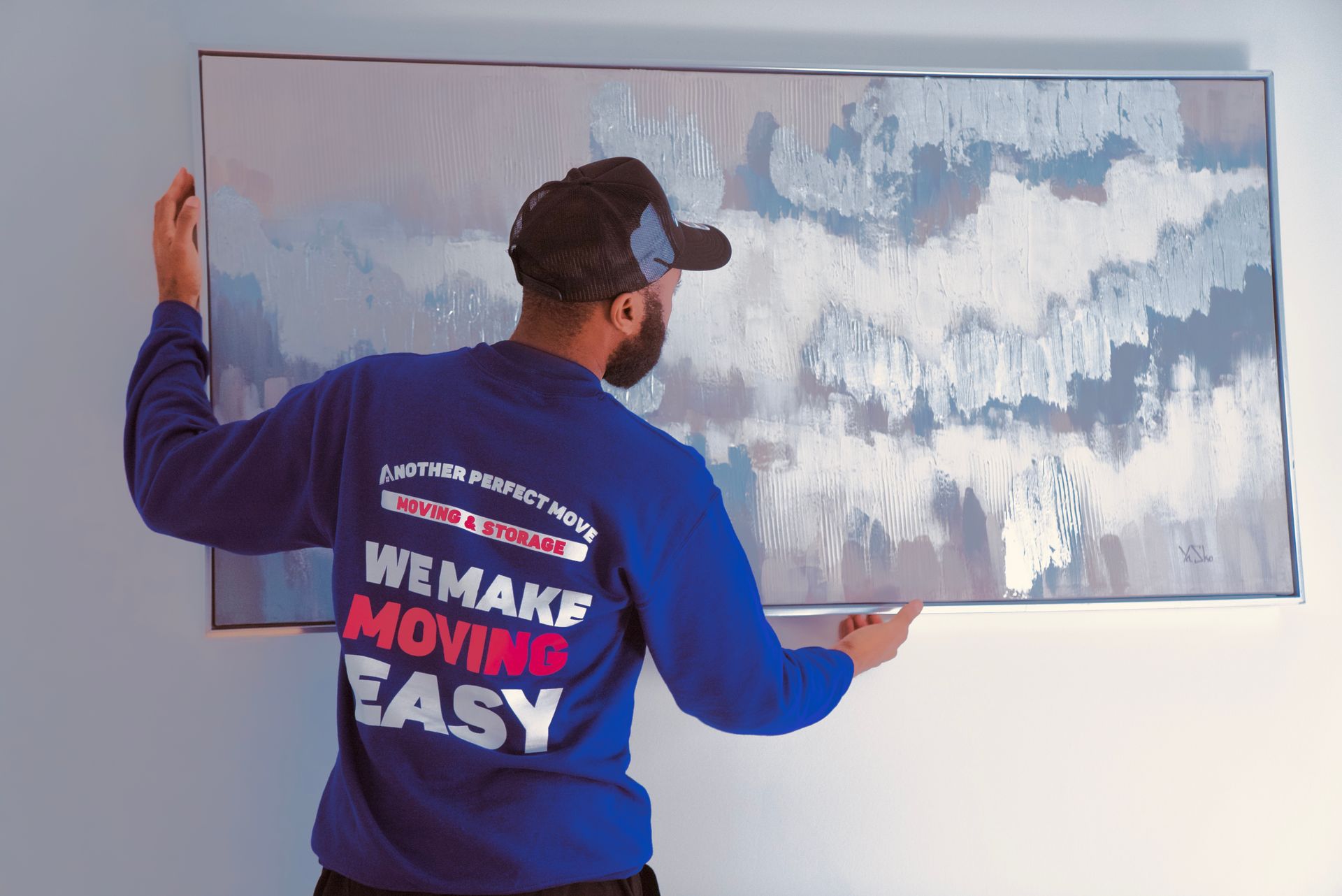 A man wearing a blue shirt that says we make moving easy
