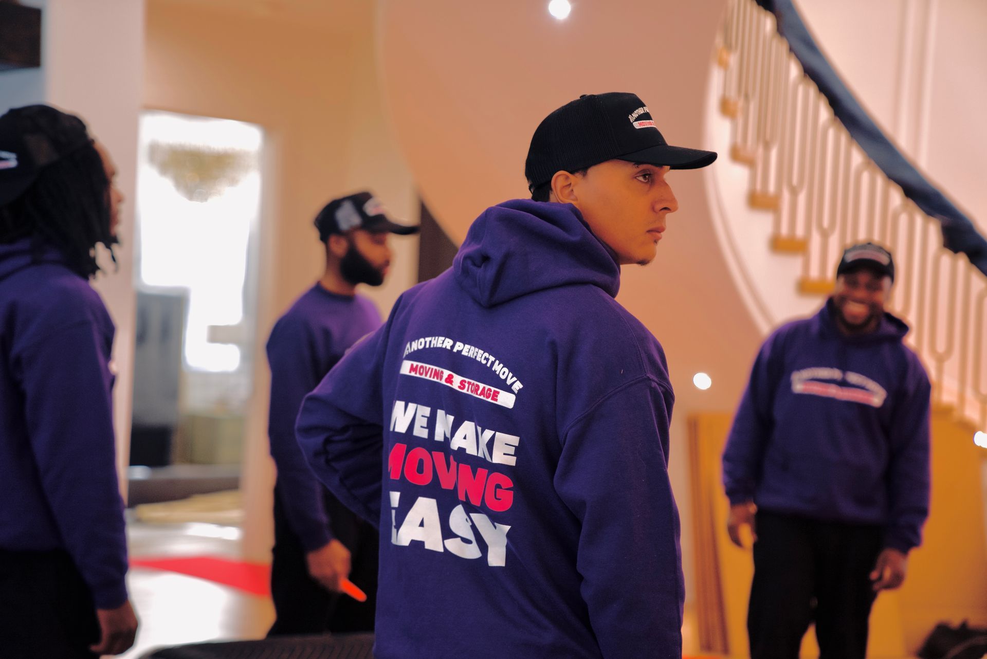 A man wearing a purple hoodie that says we make moving easy