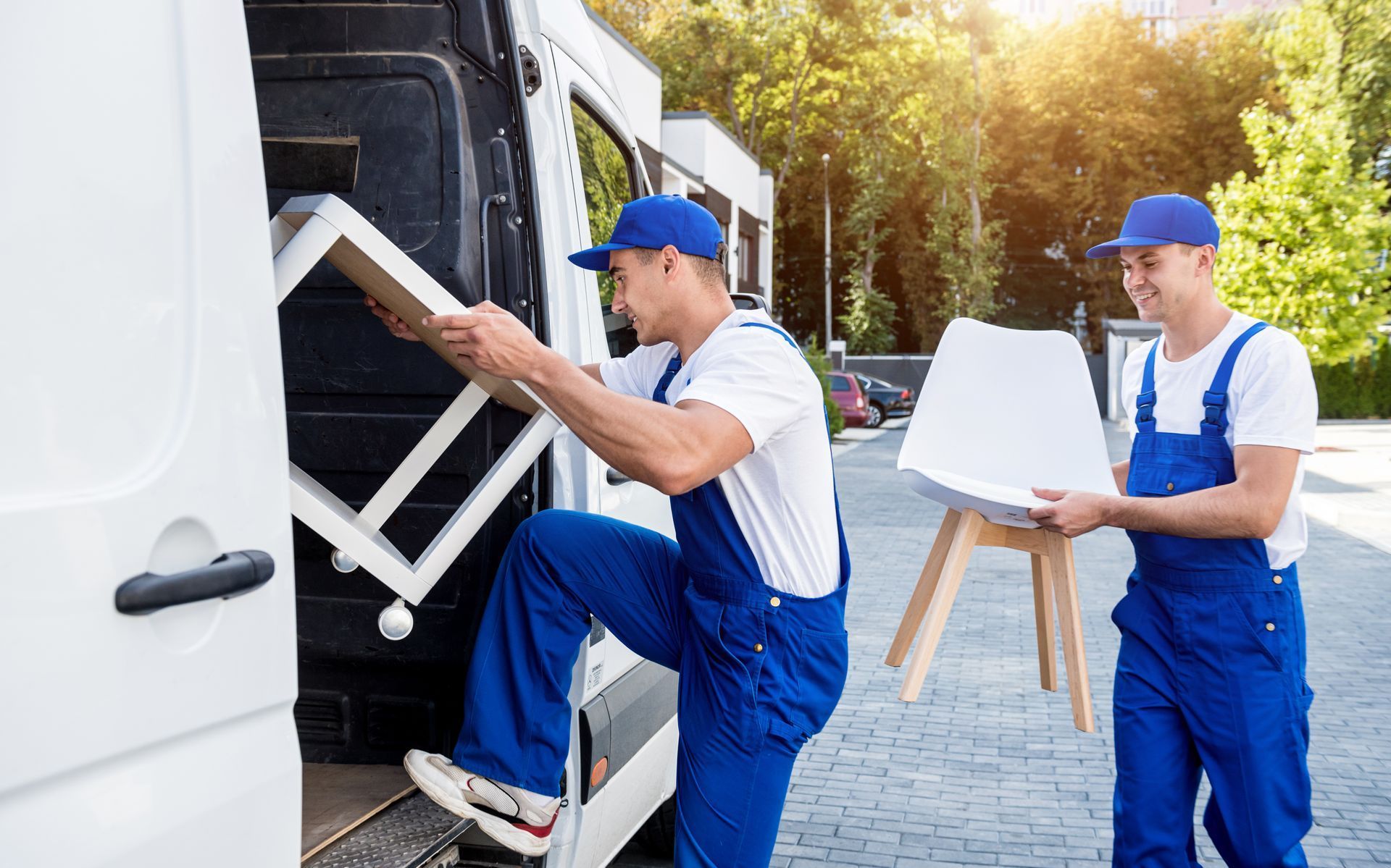 Two movers are loading furniture into a van.