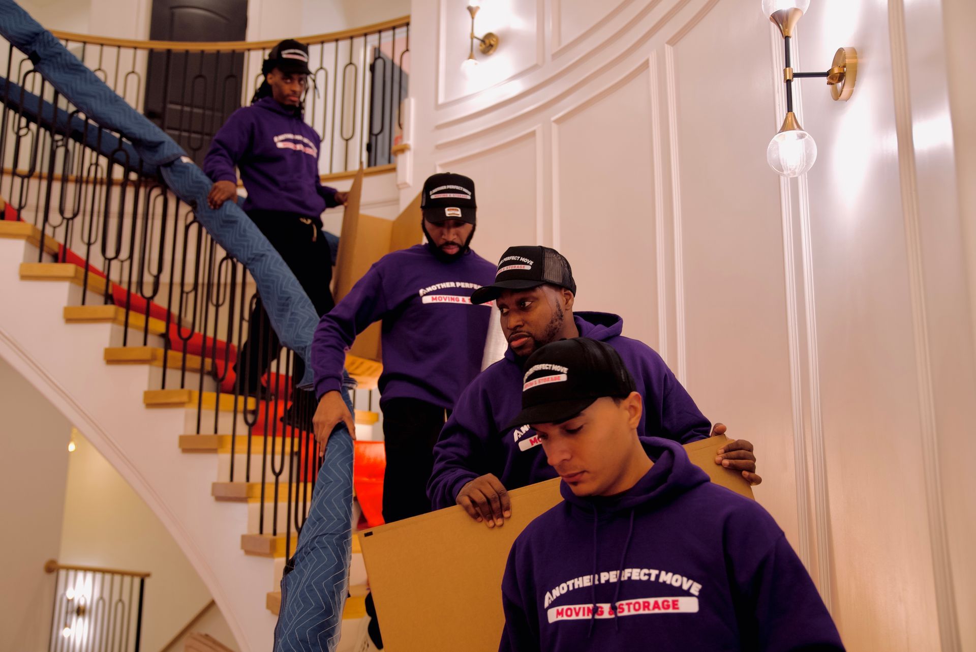 A group of movers are carrying boxes up a set of stairs.