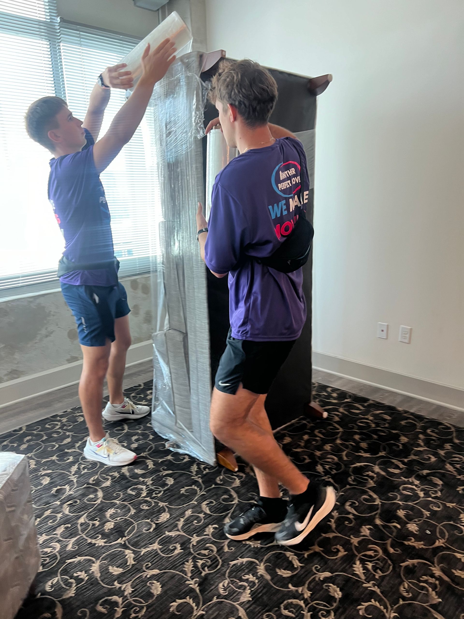Two men are moving a large piece of furniture in a room.