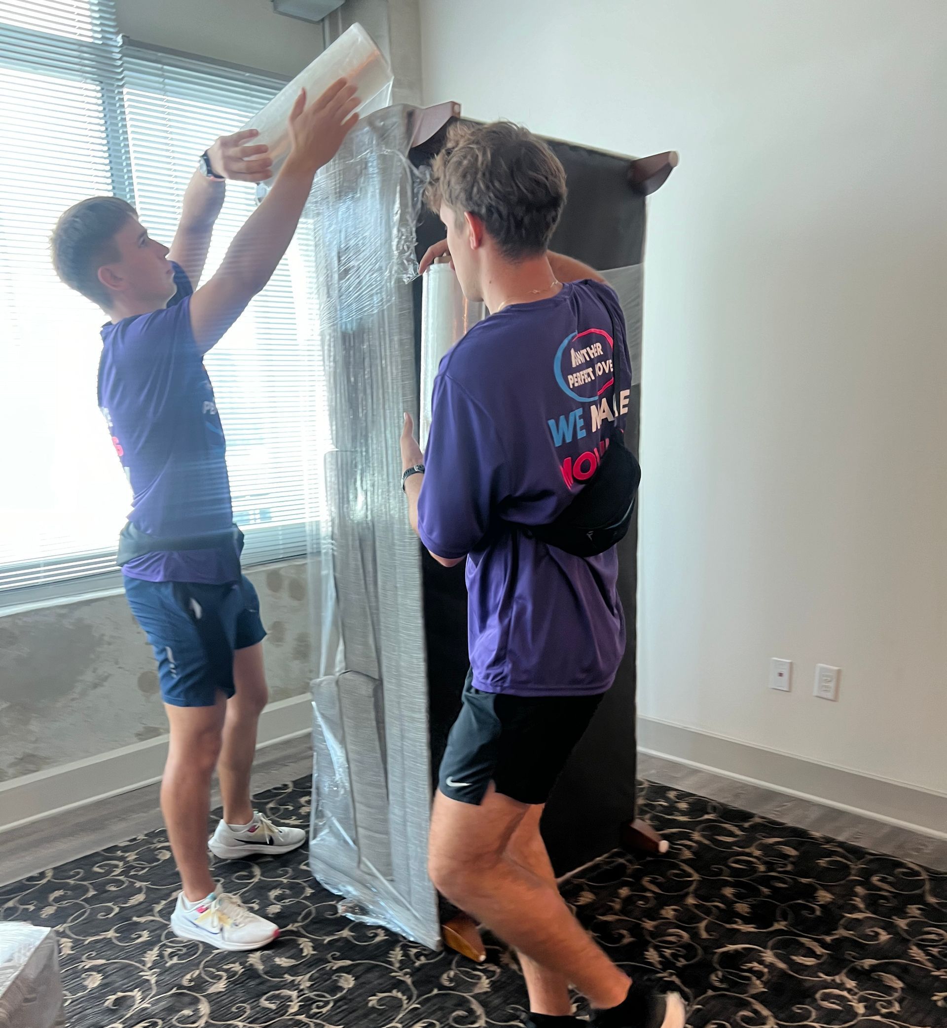 Two men are moving a large piece of furniture in a room.