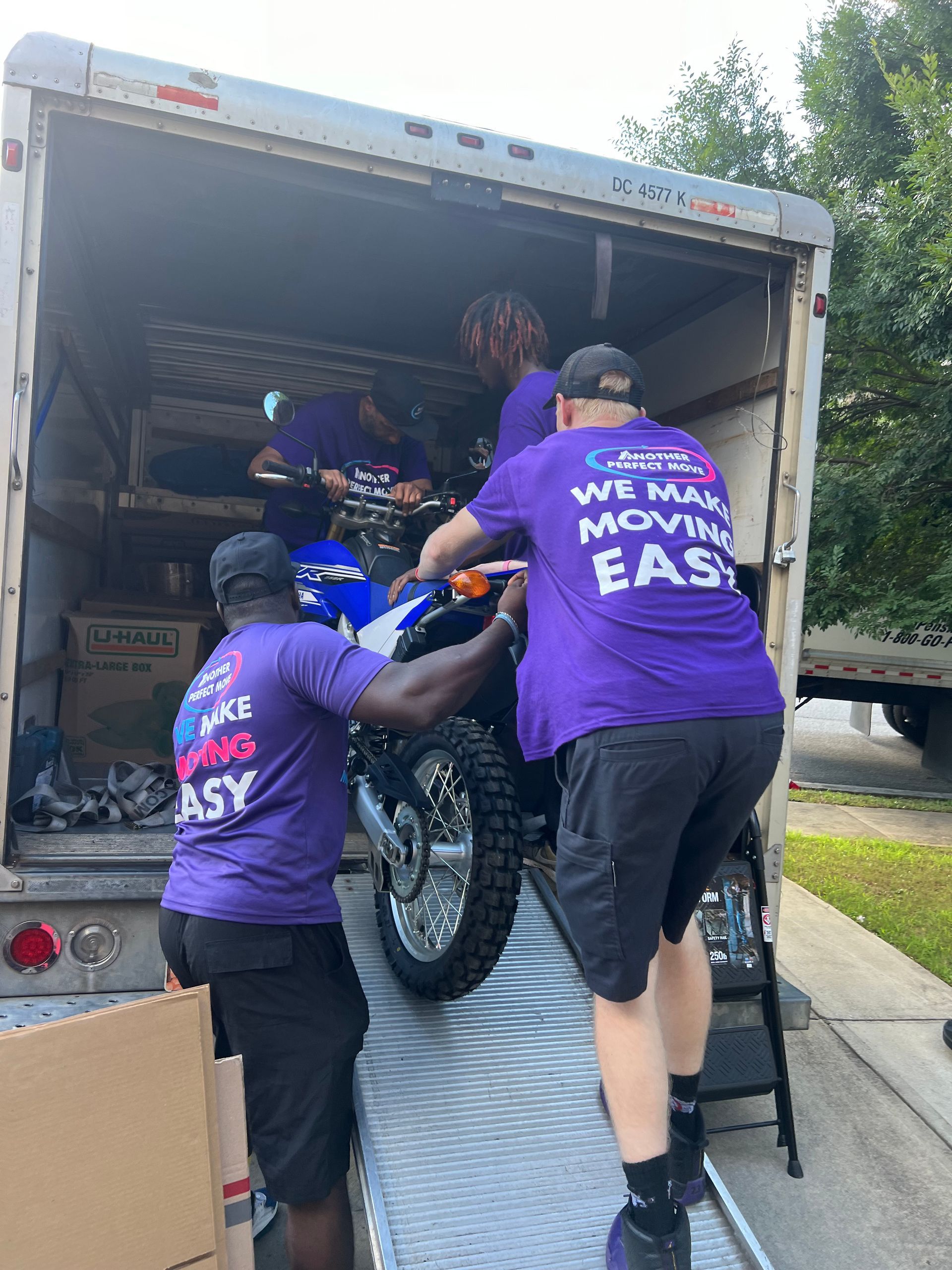 A group of men are loading a motorcycle into a truck.