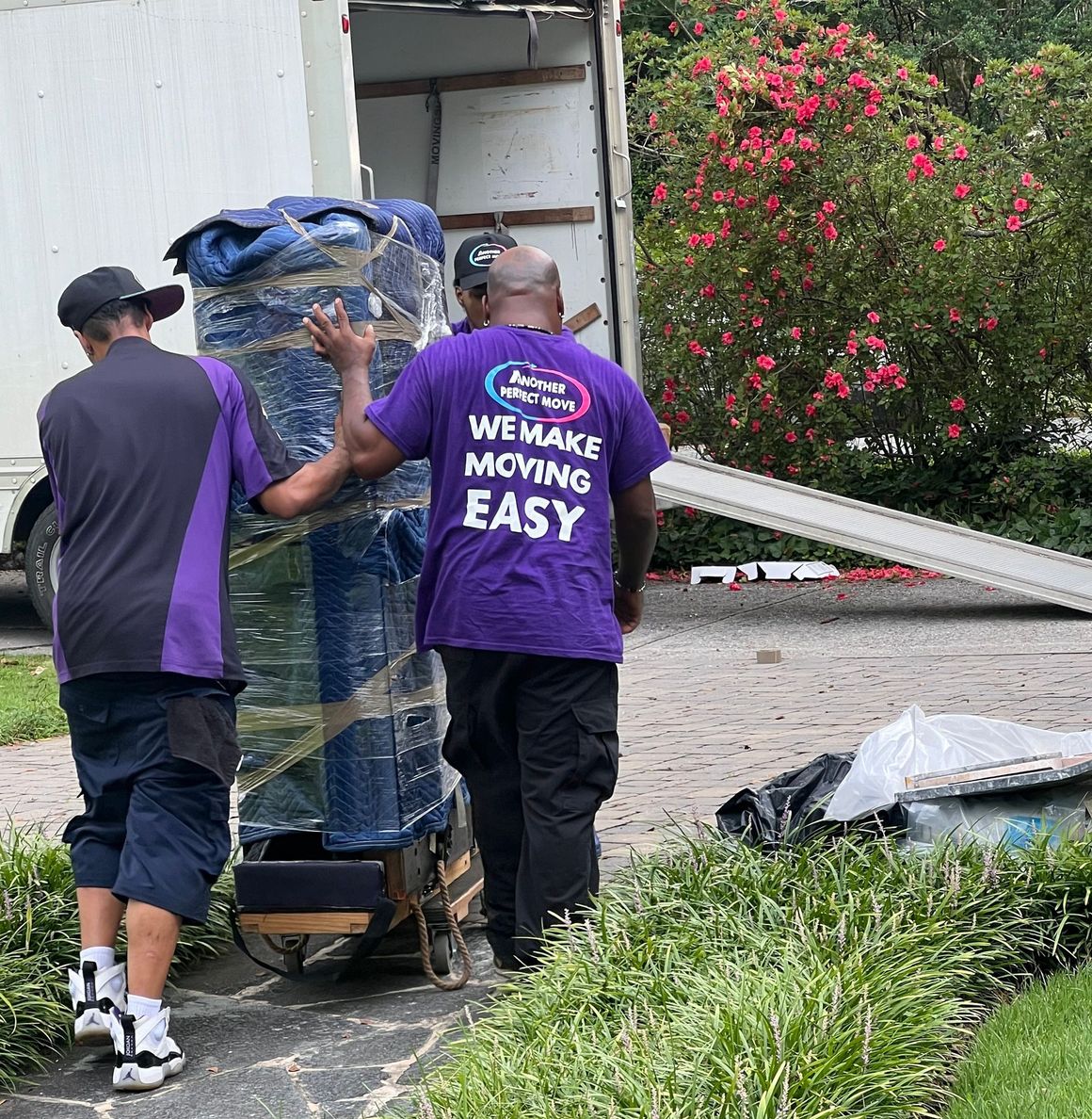 A man wearing a purple shirt that says we make moving easy