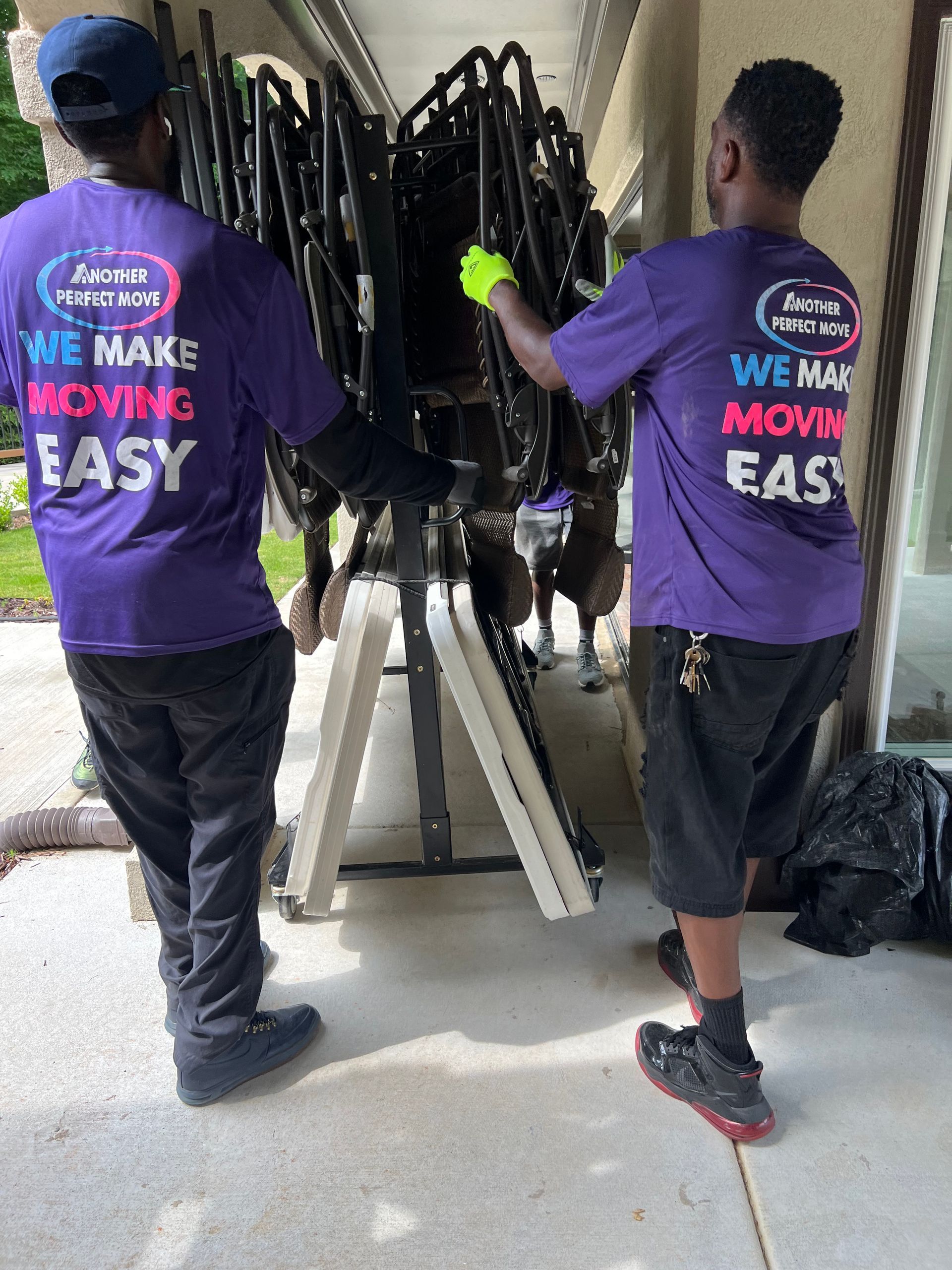 Two men wearing purple shirts that say we make moving easy