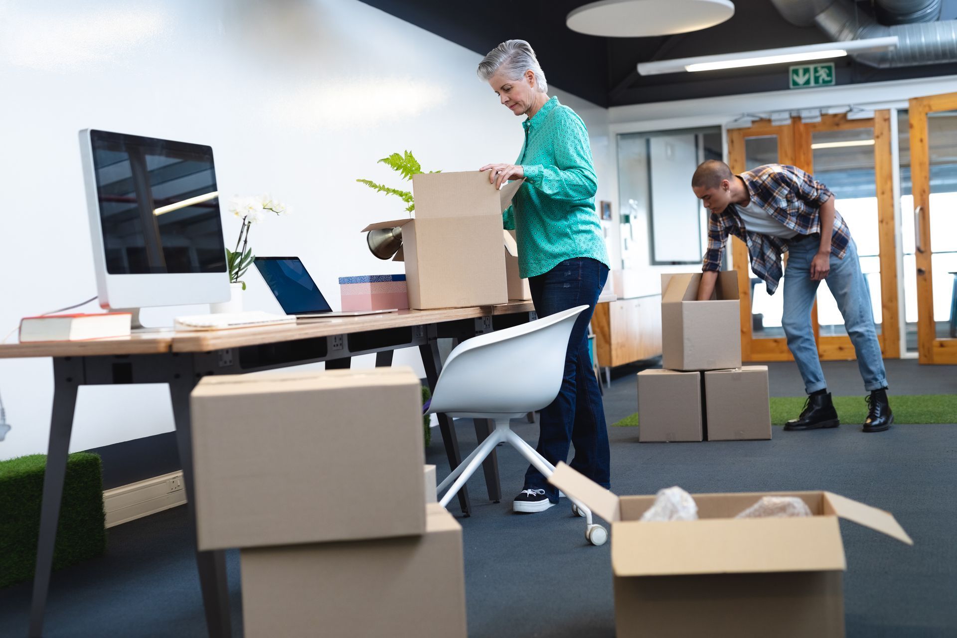 A man and a woman are moving into a new office.