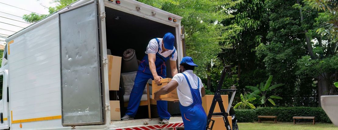 Two men are loading boxes into a moving truck.