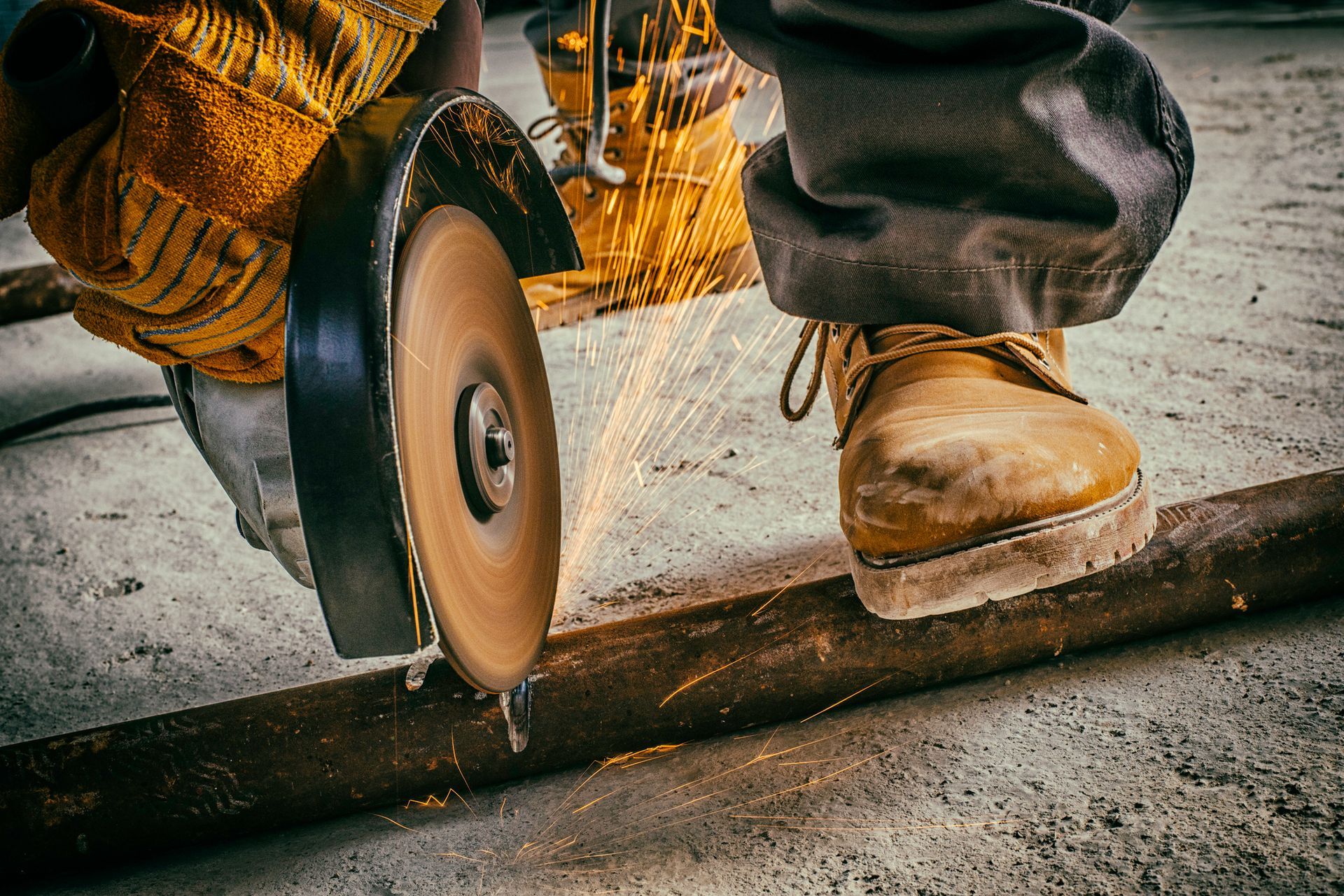 A man wearing a hard hat is plastering a wall with a spatula.