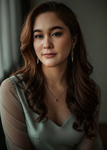 The woman is wearing a necklace and earrings and is looking at the camera.