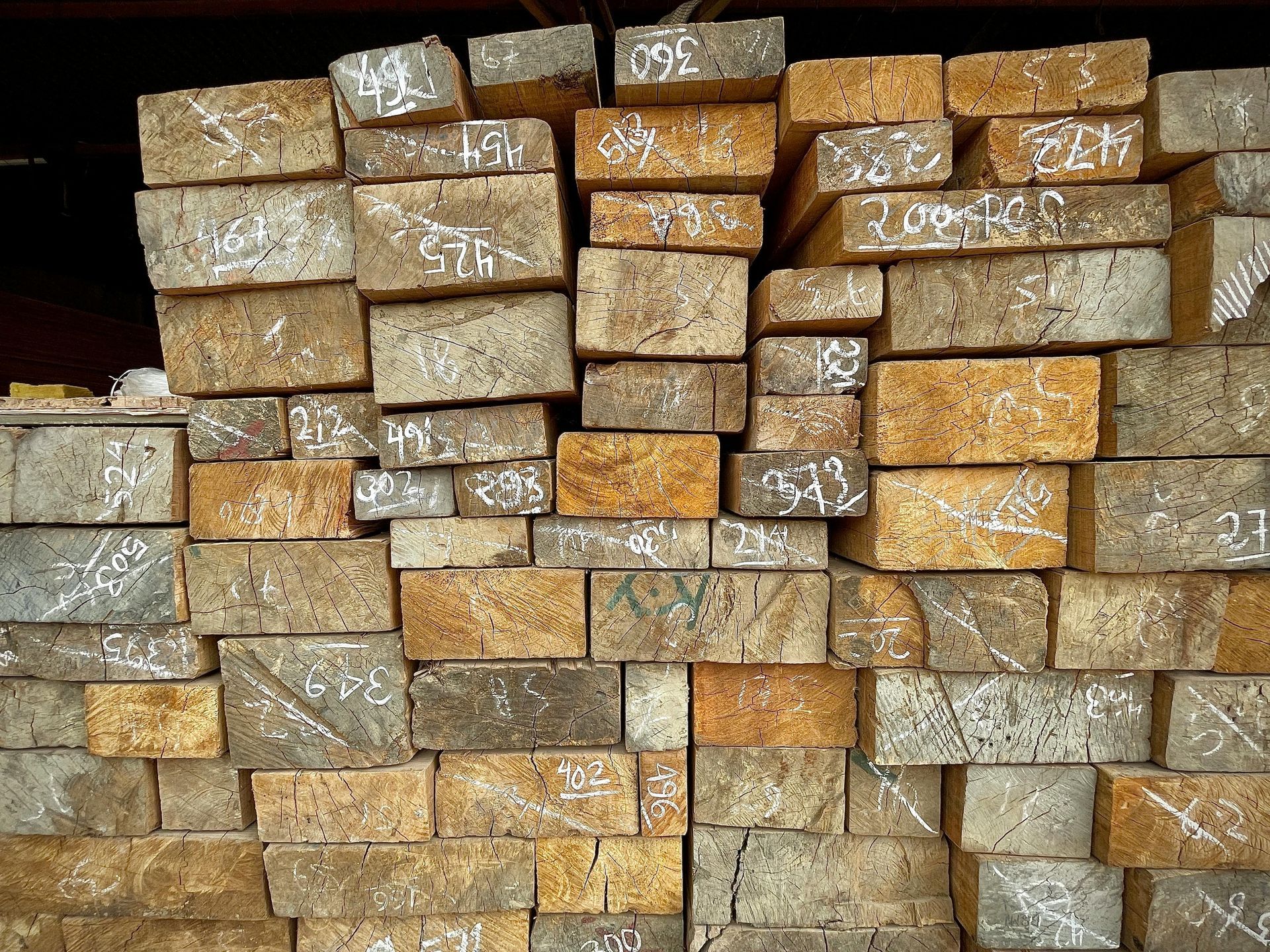Pile of weathered, rectangular bricks with white markings.