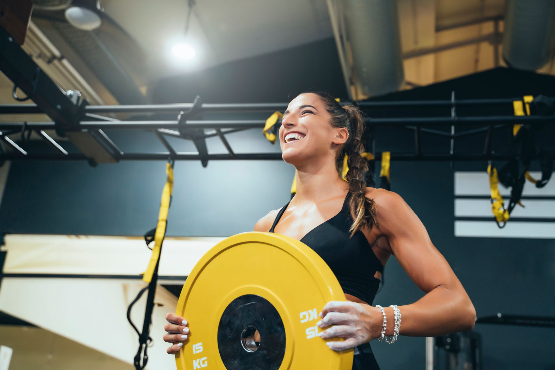 Two women exercising with battle ropes in a gym.