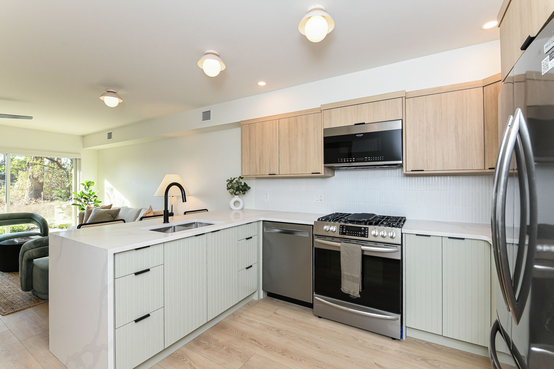 A kitchen with stainless steel appliances and wooden cabinets.