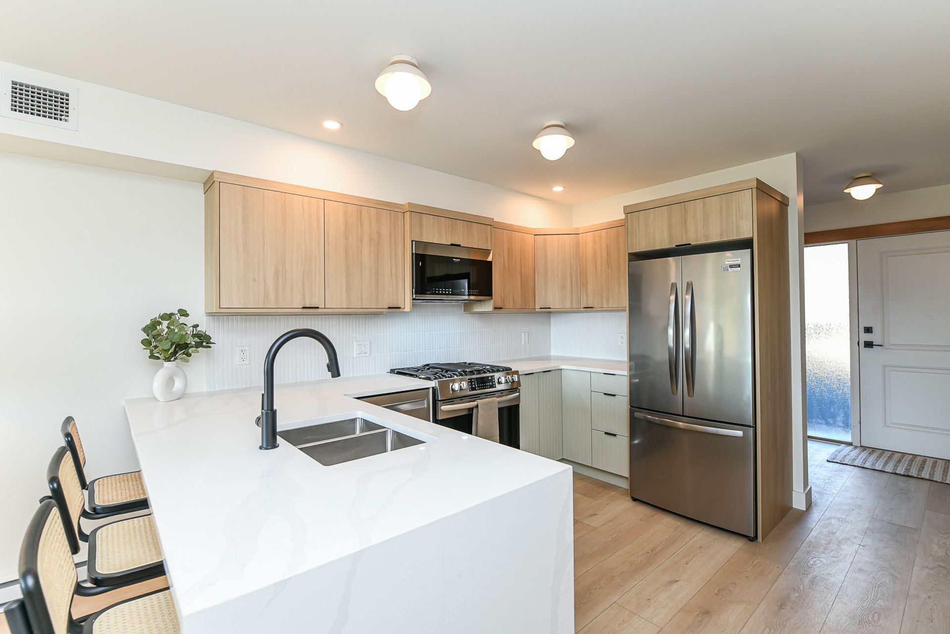 A kitchen with stainless steel appliances and wooden cabinets