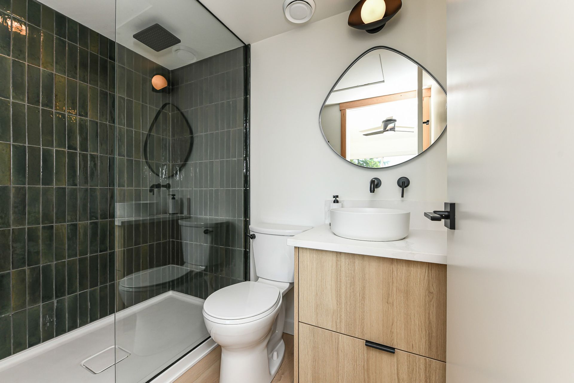 A bathroom with a toilet , sink , and shower.