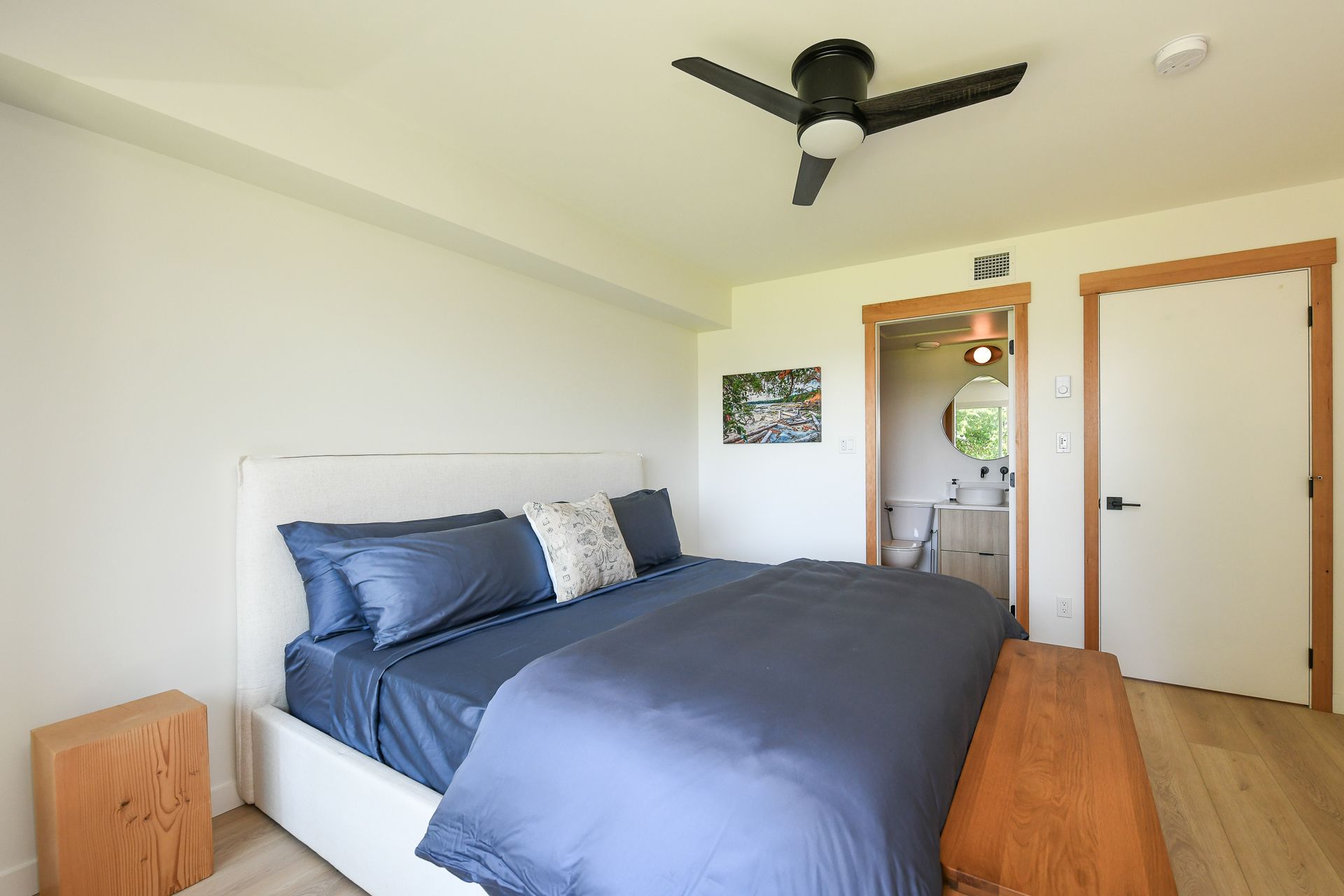 A bedroom with a large bed and a ceiling fan