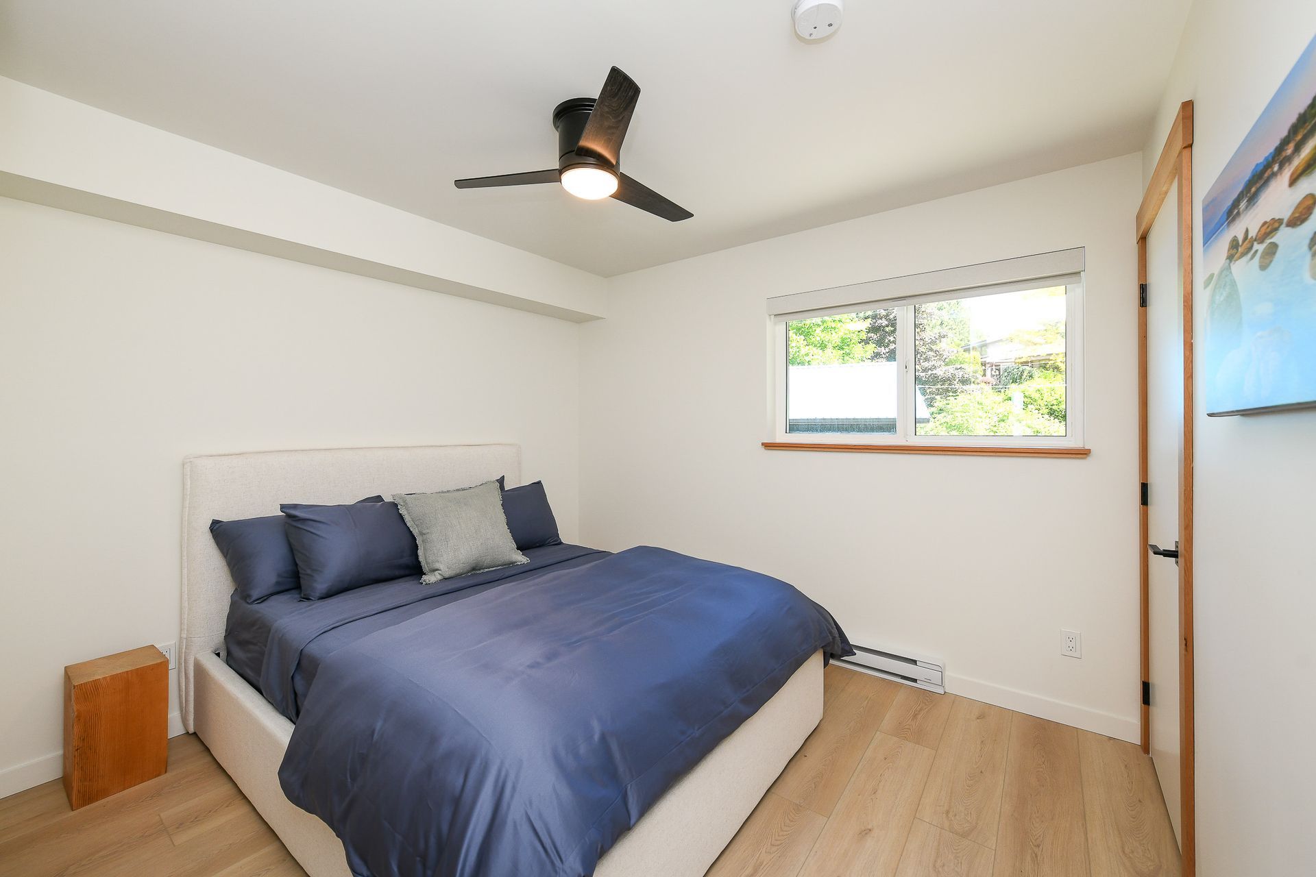 A bedroom with a large bed and a ceiling fan