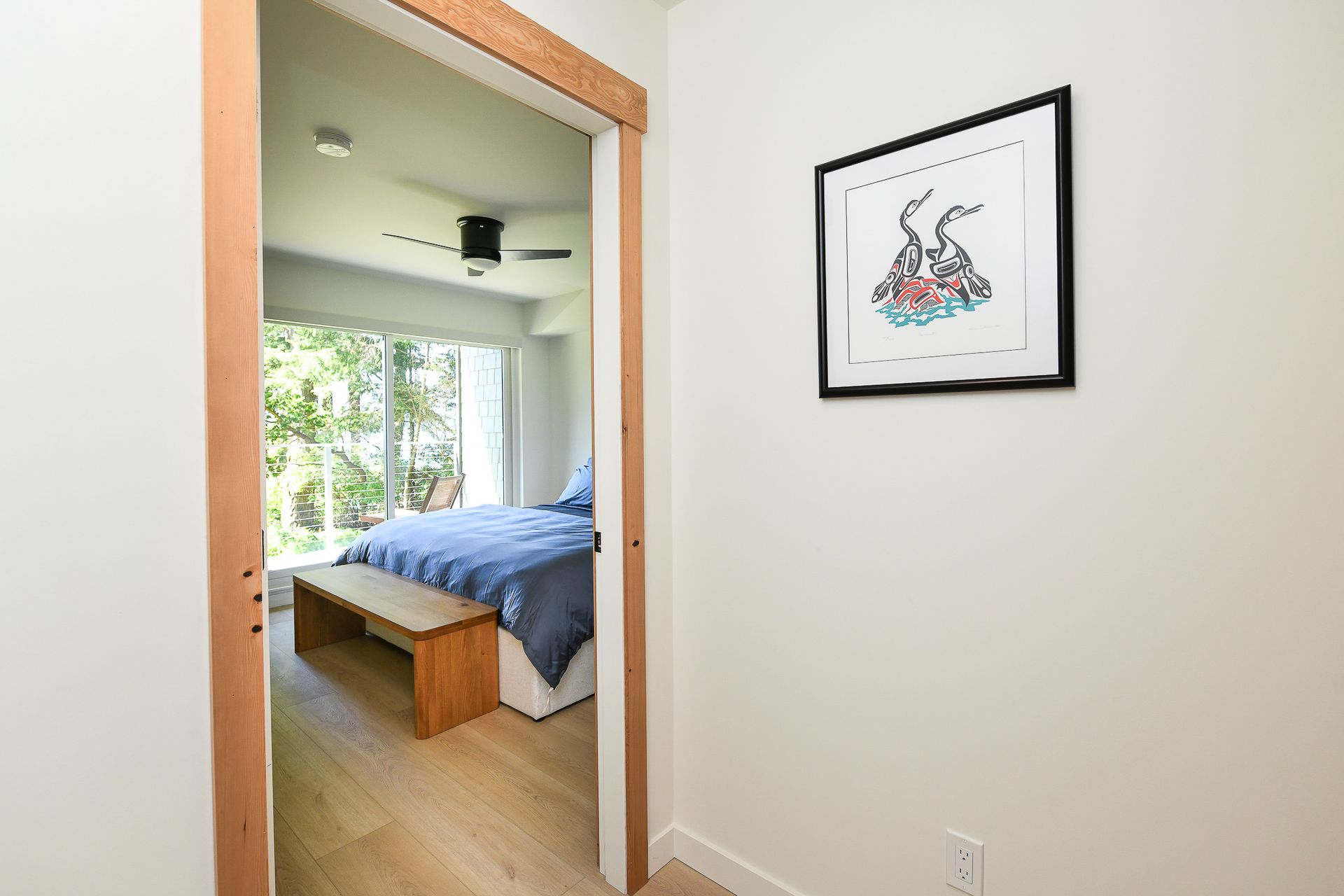 A hallway leading to a bedroom with a picture on the wall.